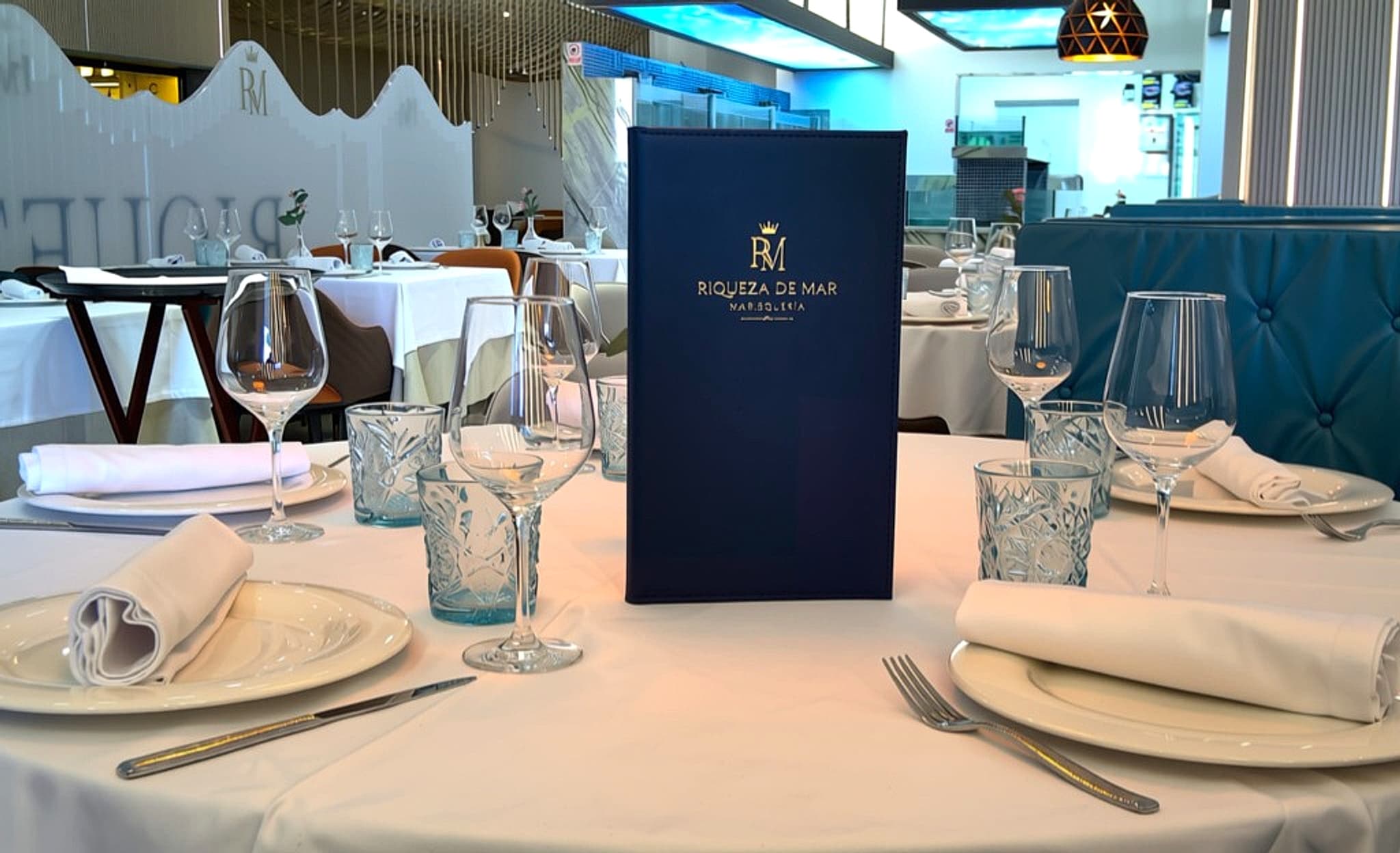 Mesa vestida y carta de Riqueza de Mar en el comedor